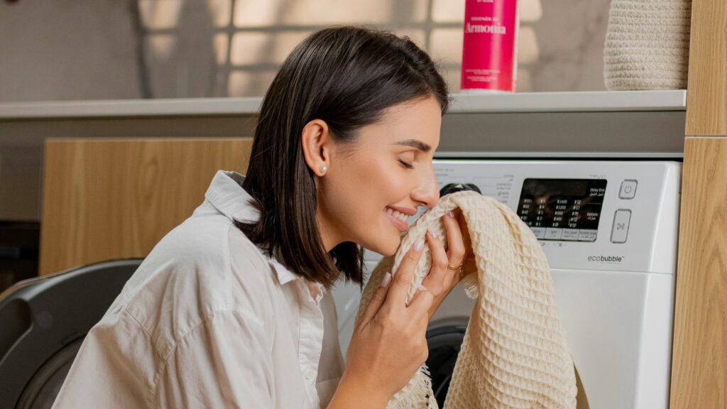 a woman sitting on the floor in front of a washing machine