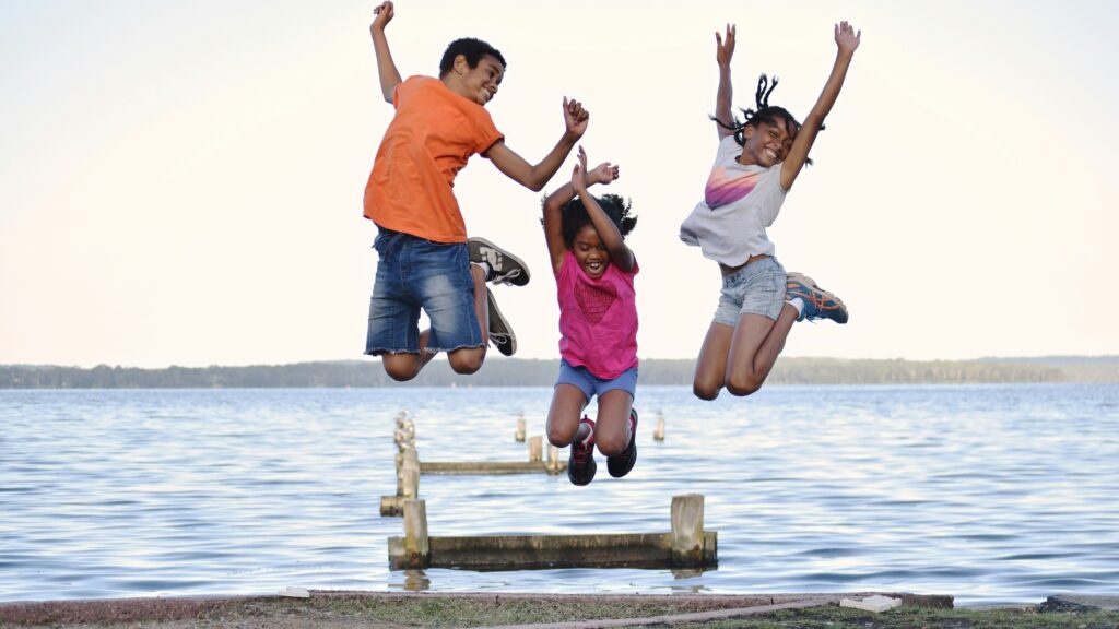 a group of people jumping on a dock