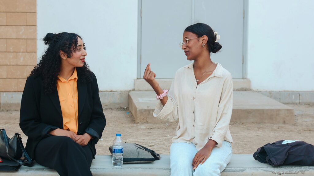 Two women talking while sitting outdoors