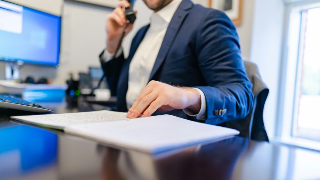 a man sitting at a desk writing on a piece of paper