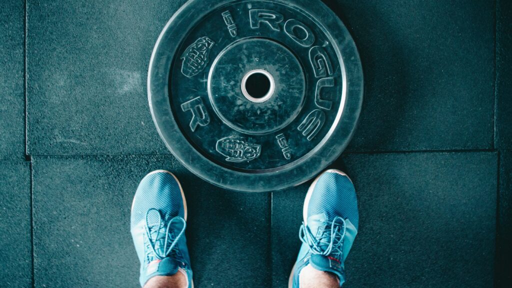 person standing beside black weights