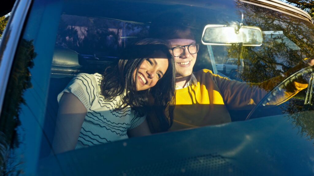 a man and a woman sitting in a car
