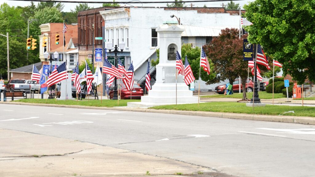 American flags line a street in a small town square.