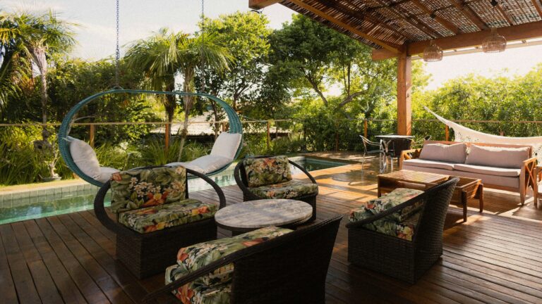 Covered patio with seating, hammock, and pool view.