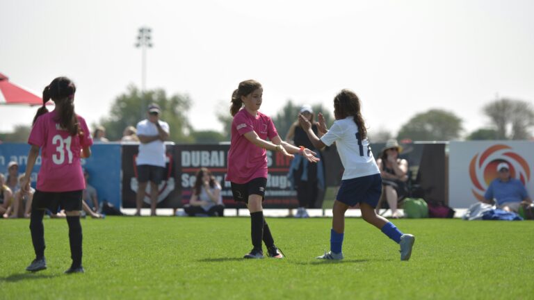 group of women playing soccer during daytime