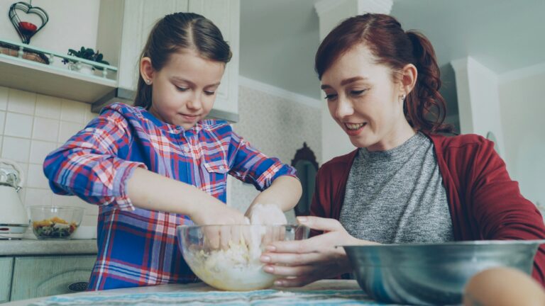 Mother and daughter bake together in the kitchen.
