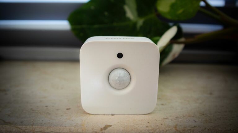 A white sensor sits in front of foliage.