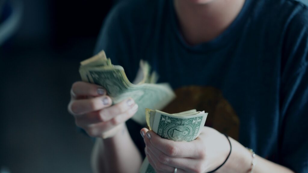 focus photography of person counting dollar banknotes