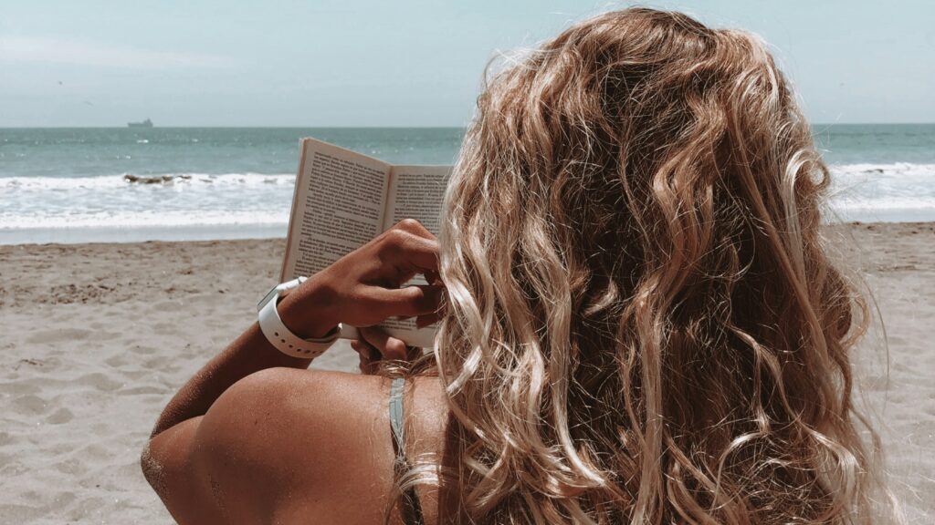 woman in brown bikini holding book