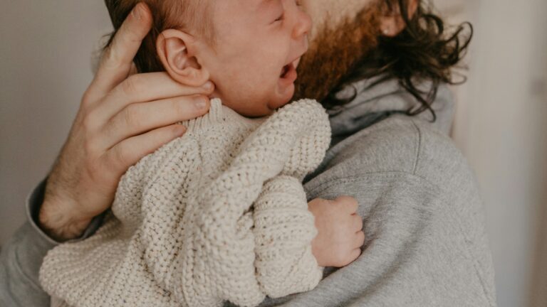 a man holding a baby in his arms