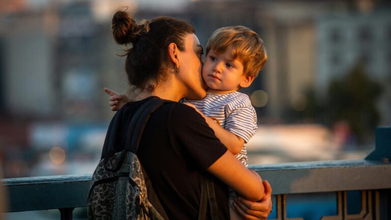 woman wearing black shirt carrying toddler boy