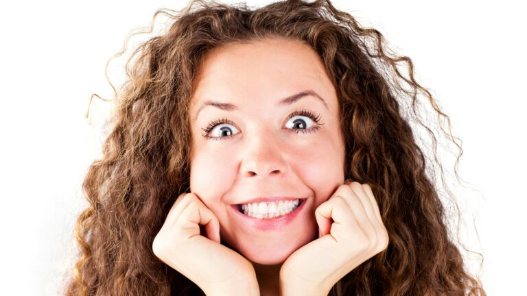 A woman with curly hair and a smile on her face