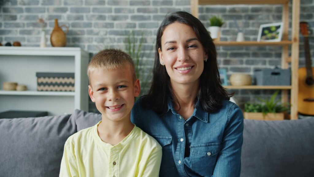 Mother and son smiling on a couch