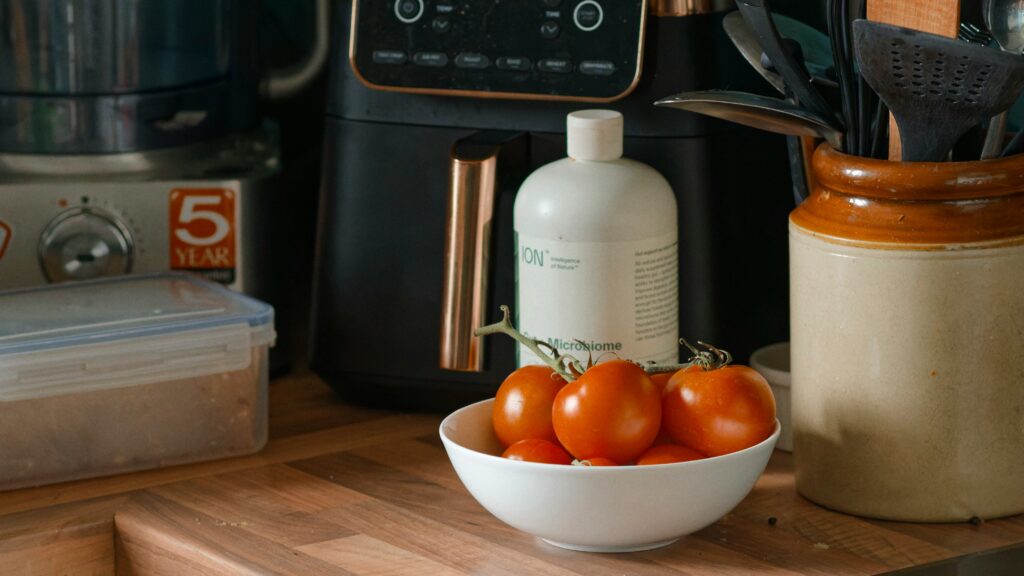Tomatoes and kitchen appliances on a counter.