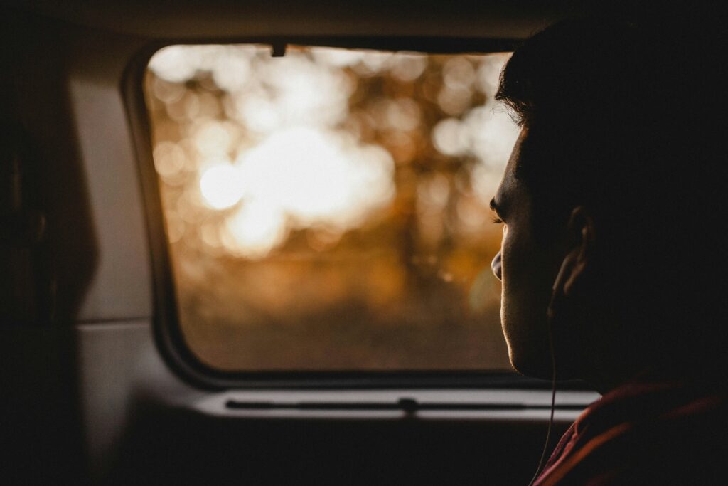 person in back seat of car looking out the window
