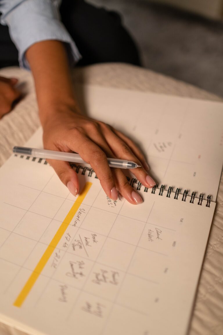 person writing events on calendar