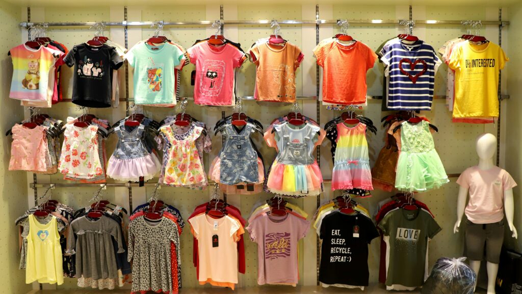 Children's clothing displayed on racks in a store.