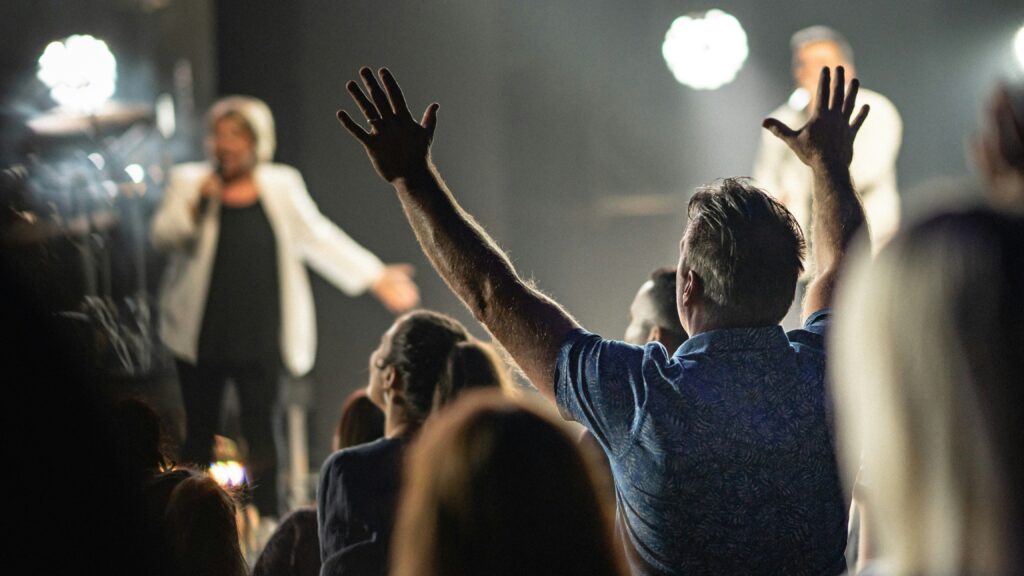 a person with the hands up in the air in front of a crowd