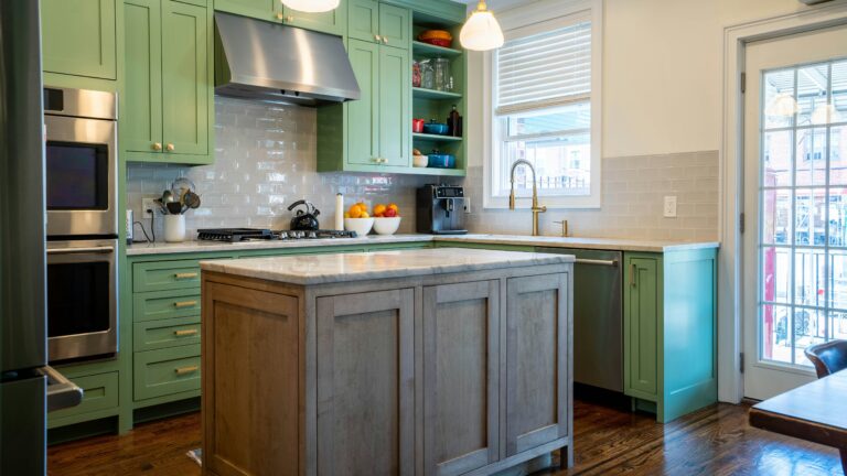 a kitchen with green cabinets and a center island