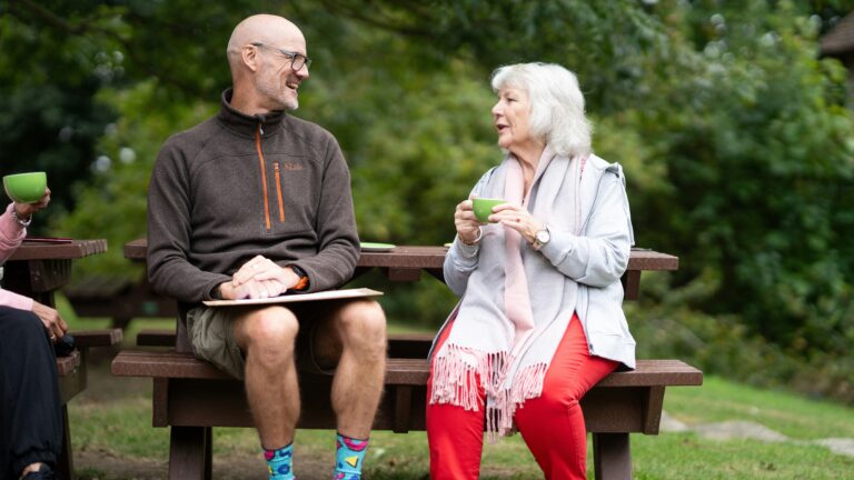 a man and a woman sitting on a park bench