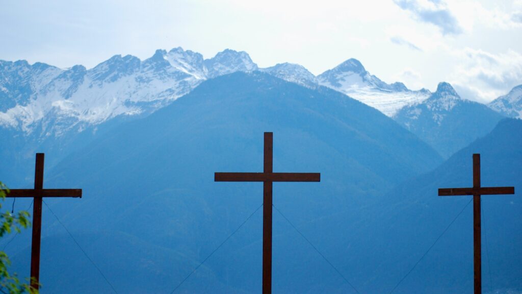 three crosses in front of a mountain range