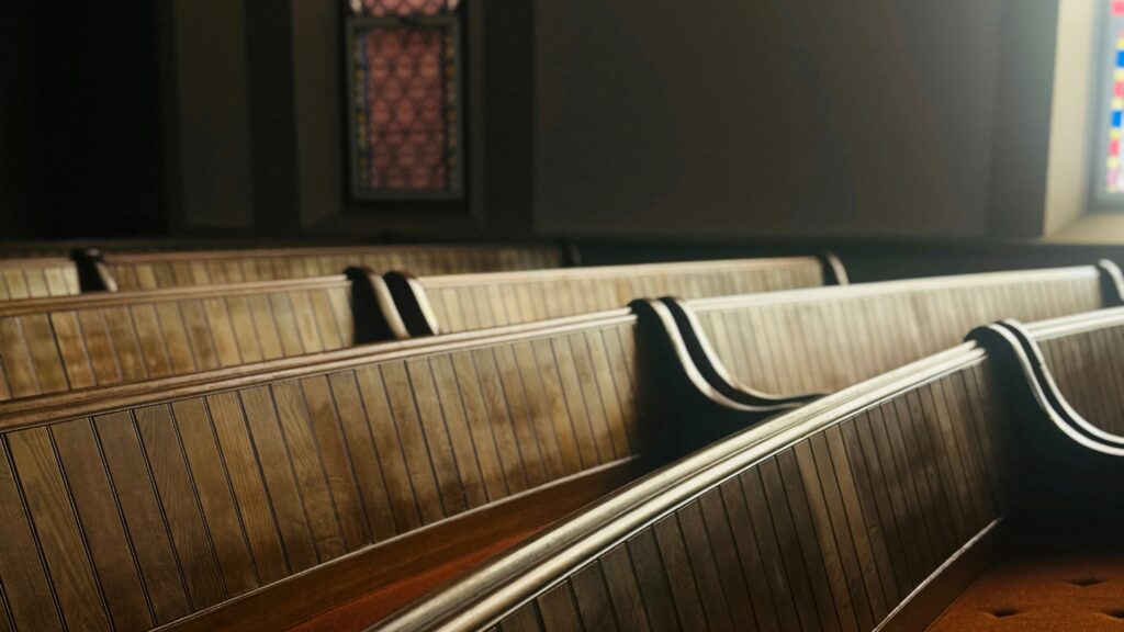 a row of pews in a church with stained glass windows