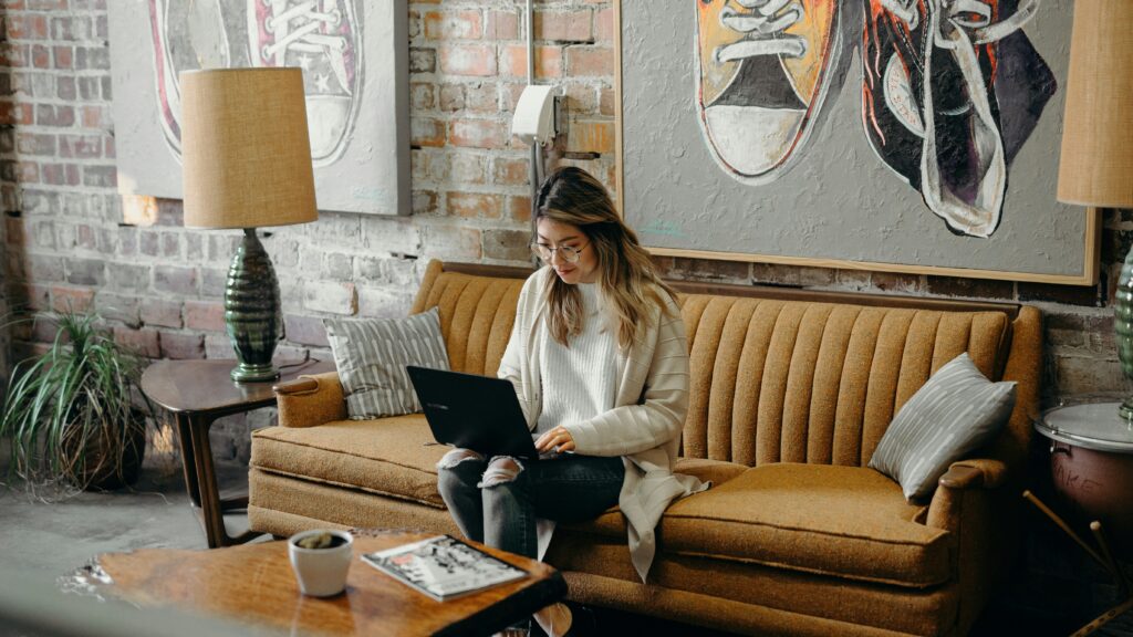 woman using laptop while sitting on chair