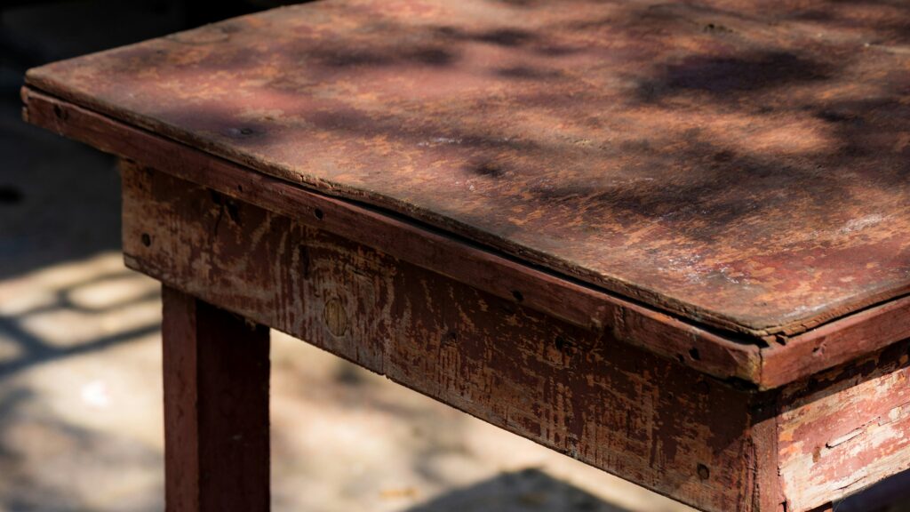 A small wooden table sitting on top of a sidewalk