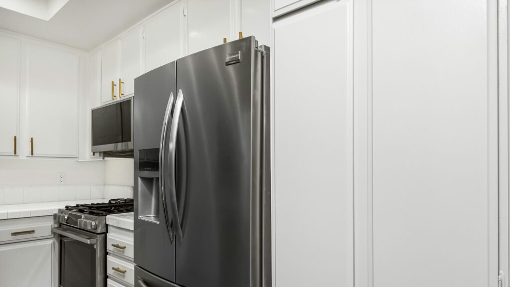 A kitchen with white cabinets and stainless steel appliances