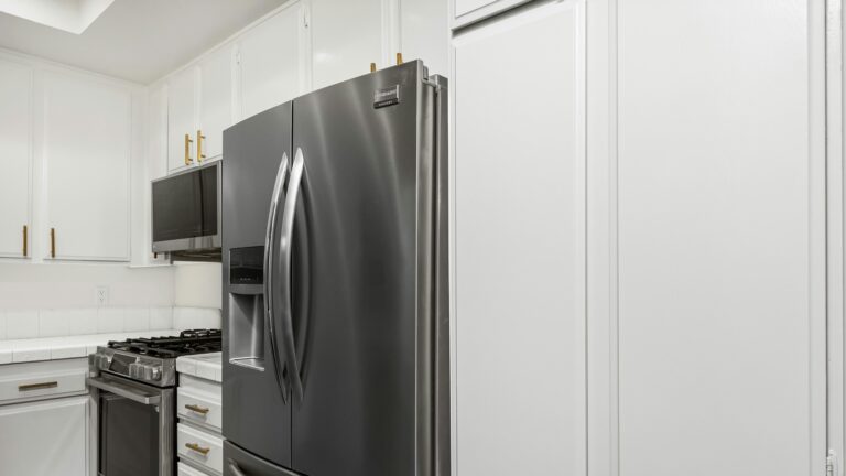 A kitchen with white cabinets and stainless steel appliances