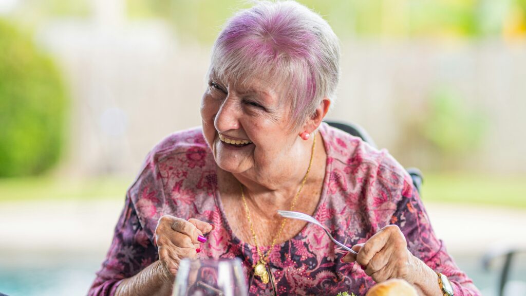 woman in purple and pink floral long sleeve shirt sitting on chair