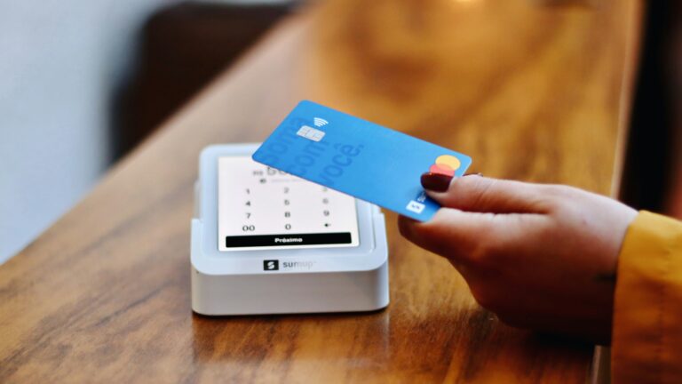 a person holding a credit card in front of a machine