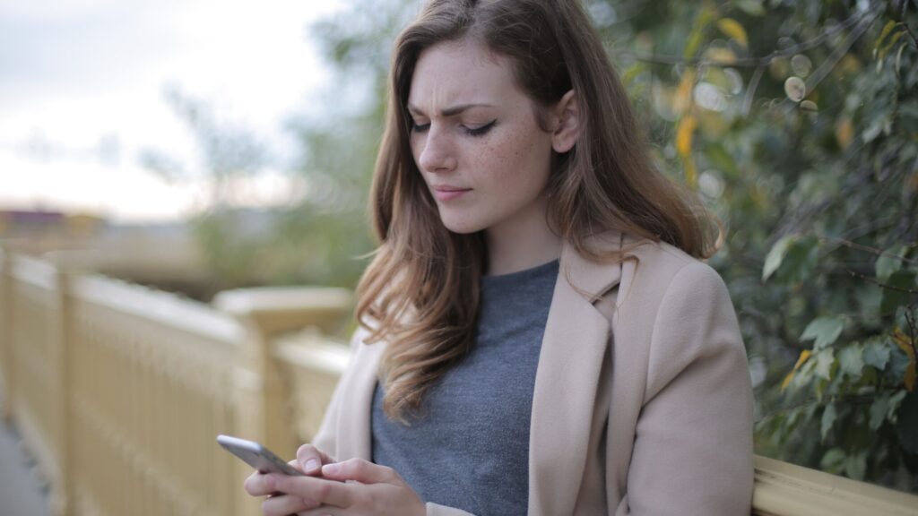 tired woman looking at cell phone