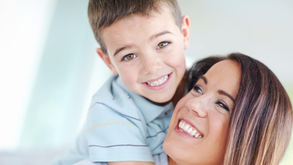 Mom son and hug on sofa for love support or care with bonding for happy childhood or weekend together at home Portrait mother and kid or child with smile for embrace or relax on living room couch