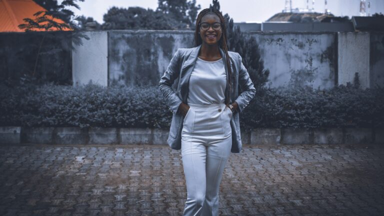 a woman in a white jumpsuit walking down a brick walkway