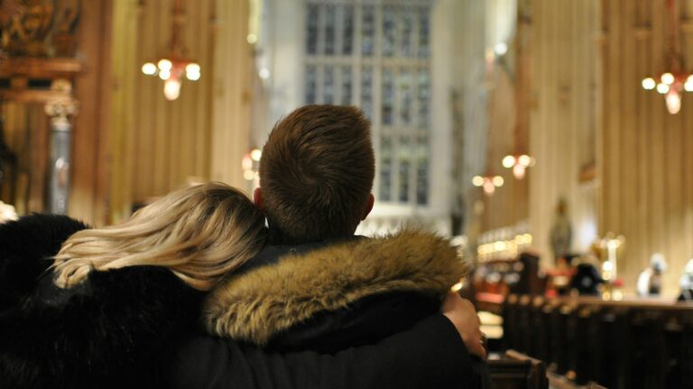a man and woman sitting in a church
