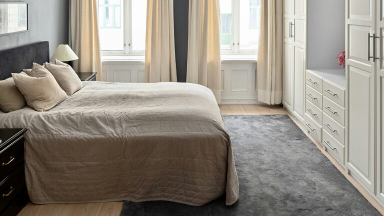 A bedroom with a large bed and a dresser