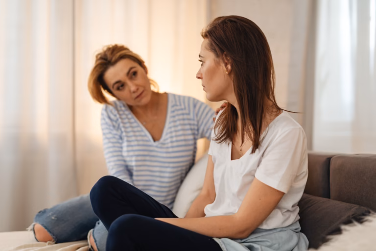 Illustrative stock photo of two adult women in conversation at home; the people pictured are not the people described in the story.