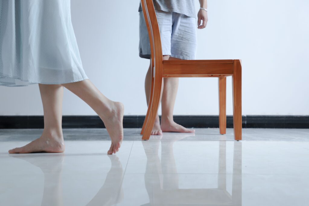 persons standing beside armless chair