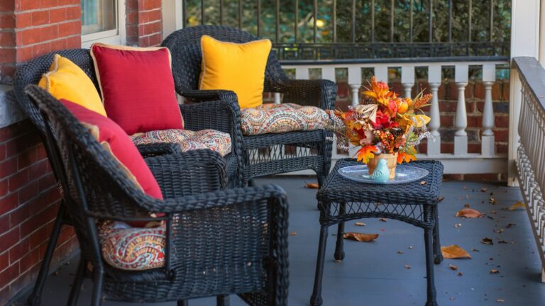 a couple of wicker chairs sitting on top of a porch
