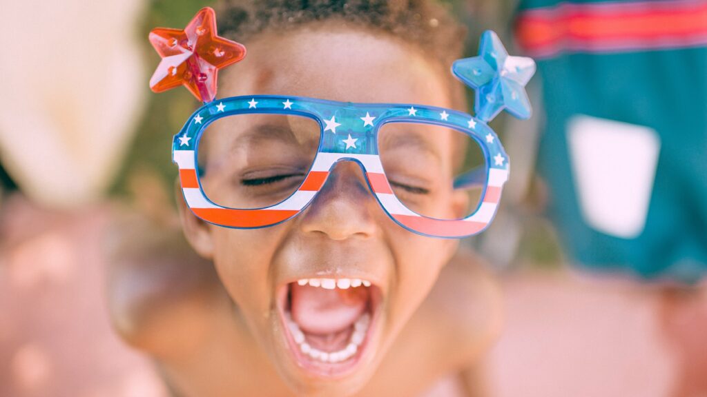 boy wearing American flag print eyeglasses sticking his mouth open