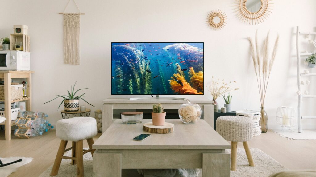 black flat screen tv turned on near white wooden table