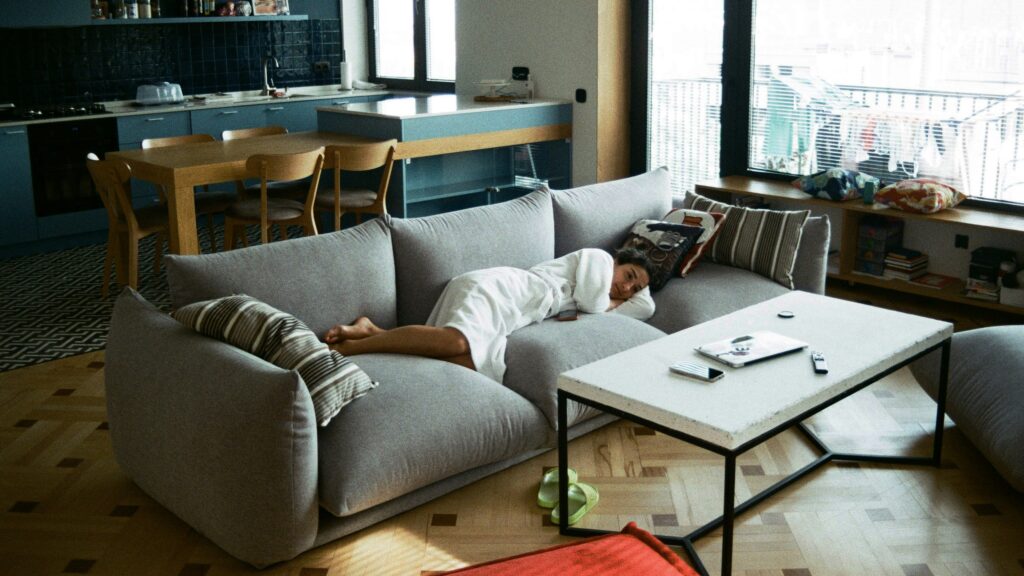 a man laying on a couch in a living room