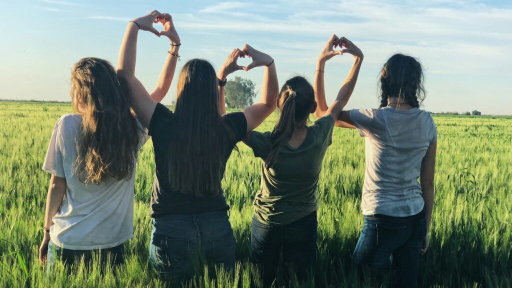 women forming heart gestures during daytime