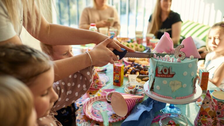 a group of people sitting around a table with a cake