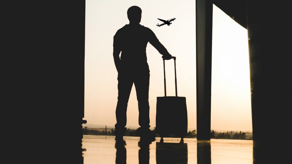 silhouette of man holding luggage inside airport