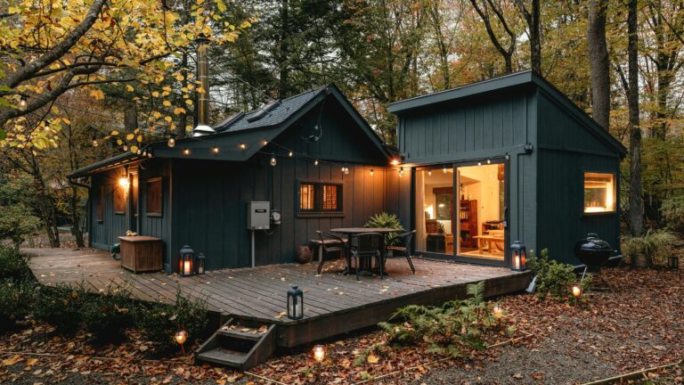 a small cabin with a deck in the woods