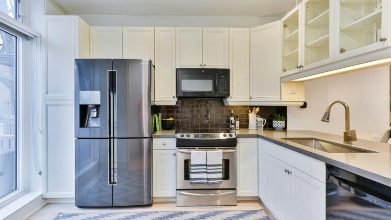 silver french door refrigerator beside white wooden kitchen cabinet