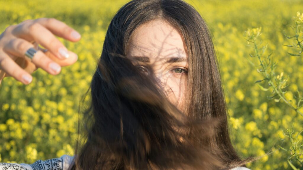 woman wearing white shirt covering face with her hair