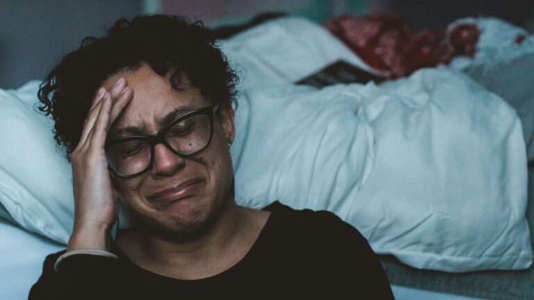 person crying beside bed